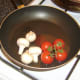 Frying cherry tomatoes and mushrooms.