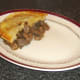 Pastry is laid on top of steak, liver and kidney pie filling.