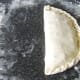 Pastry is folded over pasty filling and crimped
