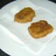 Corned beef fritters are drained on kitchen paper