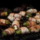 Jalapenos stuffed with cheese and wrapped in bacon on the grill