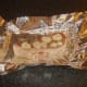 Back bacon steak is added to foil with oil, seasoning and onion