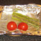Oiling asparagus and tomato for griddling