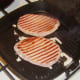 Bacon medallion steaks are turned in griddle pan