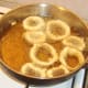 Battered onion rings are added to hot oil