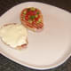 Egg white and salsa are laid/spread on bacon steaks