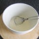 A balloon whisk is used to whip cream to desired consistency