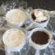 Spooning cream cheese topping on to cheesecakes
