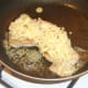 Cheese is scattered on turkey breast for melting