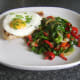 Pork chop, fried egg and sauteed cabbage combination are plated