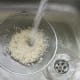 Rice is washed through a sieve before it is cooked