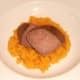 Ostrich steak halves are laid on sweet potato mash