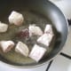 Floured ostrich steak pieces are added to frying pan