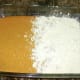 The cake mix has been partially poured over the pumpkin mixture.