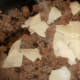 Add cheese to the meat and mix well as it melts.