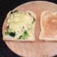 Cheese is melted over broccoli and bacon