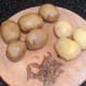 Cooked and cooled potatoes are carefully peeled for pan roasting
