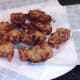 Broccoli, sweetcorn and potato fritters are drained on kitchen paper