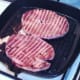 Gammon steaks are turned in griddle pan