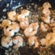 Stir the shrimp, garlic, shallot, capers and basil around in the olive oil and butter until the shrimp has turned pink, which means it is cooked.
