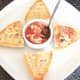Spooning tomato, basil and oregano potted crayfish tails on to cheesy bread roll toast