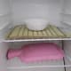 The piece of tempeh for making the starter is in the incubator. A hot water bottle is placed on the lower rack.
