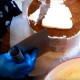 Hold the bench scraper flat against the cake and spin the cake against the scraper. Remove the excess icing in a different bowl than your original buttercream.