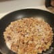 Chopped walnuts and sugar in the frying pan.
