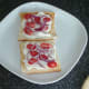 Tomatoes and red onion are scattered over cream cheese