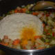 Adding the gravy to the vegetables.