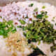 The batter with the chopped ginger, chopped dry coconut, curry leaves, and green chili