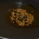 Cumin and pepper corns being fried in the pan