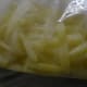 Half-fried potatoes collected in a ziplock pouch, ready for the freezer.