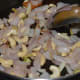 Step three: Stir-cook onion, ginger, garlic, and cashew nuts.