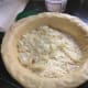 Laying onions and cheese in the pizza shell.