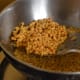 Step six: Remove them on a paper towel. Add fried peanuts, curry leaves, and a mix of chili powder, salt, and sugar.