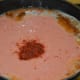 Step three: Add tomato and cashew nut paste to the pan. Add Kashmiri chili powder.