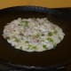 Prepare your chopped onion and other ingredients. Make a pancake using the batter. Top it with the onion mix. Gently press the top.