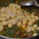 Step seven: Add cooked chickpeas. Mix well. Cook for a few minutes on a low fire.