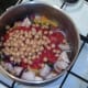 Tomatoes and chickpeas are added to pot