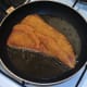Turmeric pork fillet is added to frying pan