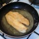 Tilapia fillet is turned to fry on second side
