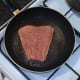 Salmon is laid in hot frying pan