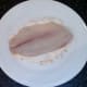 Tilapia fillet is patted in seasoned flour