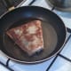 Salmon is turned in frying pan