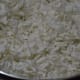 Step two: Dry-fry thin rice flakes, adding only a few drops of oil.