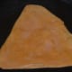 Step nine: Heat a griddle or a flat pan. Add a few drops of ghee. Place the triangle on it.