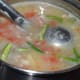 Step four: Take mashed lentil-tomato mix, slit green chilies, and crushed ginger-garlic in a vessel.
