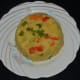 Yummy vegetable upma is ready to serve! Put 5 tablespoons of hot upma to a round bowl. Tap the sides. Invert it on a serving plate. Garnish with sev (tidbits) on top. Enjoy!