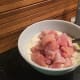 The chicken being put into the marinade